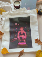 totebag illustré Stella, posé à plat avec son carnet associé de sorcière magique