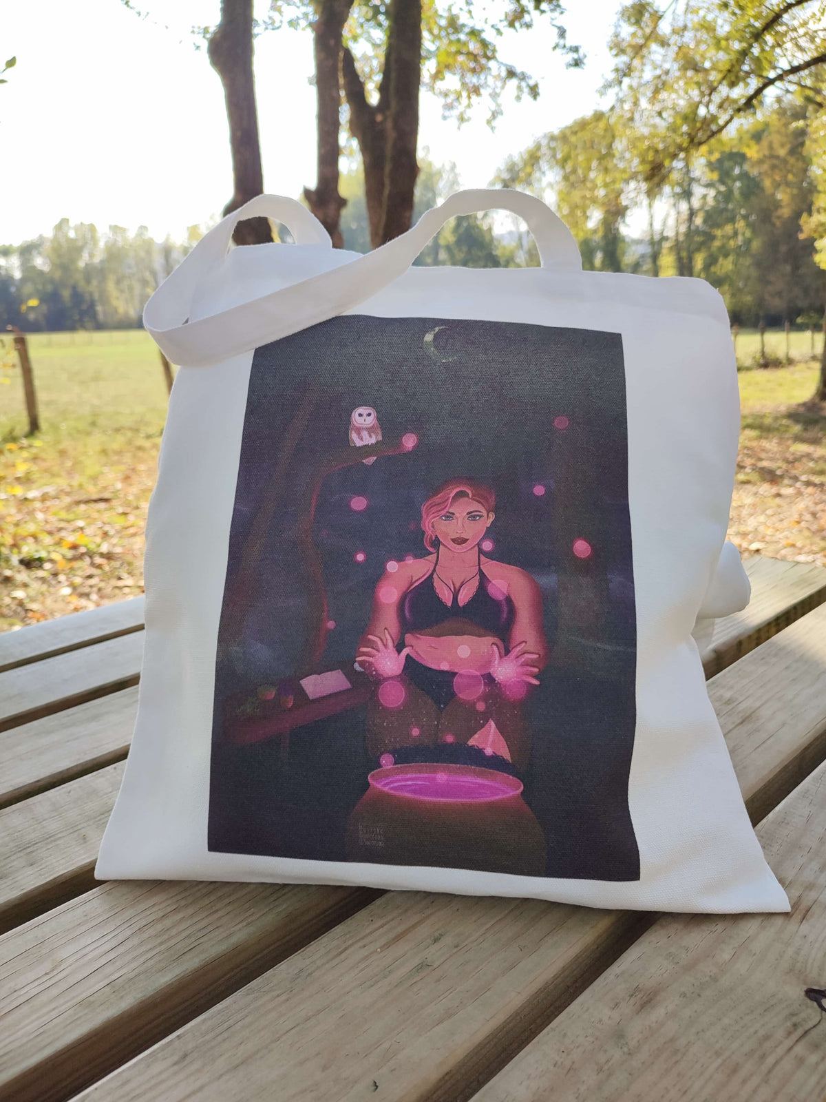 totebag rempli posé sur une table en extérieur, illustration Stella sorcière en forêt
