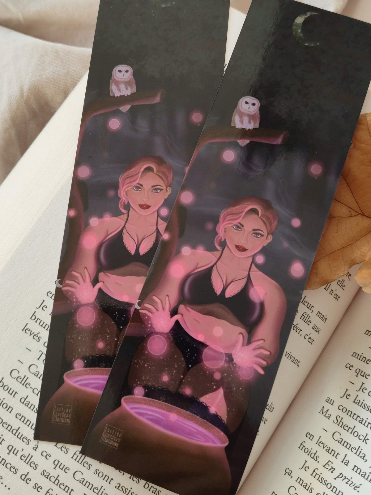 gros plan sur le recto et le verso du marque pages Stella : une sorcière sexy en noir, mèche rose faisant de la magie rose devant un chaudron magique et accompagnée de sa chouette au clair de lune en forêt