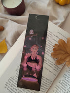 marque-pages illustré Stella, sorcière faisant de la magie rose en forêt accompagnée d'une chouette