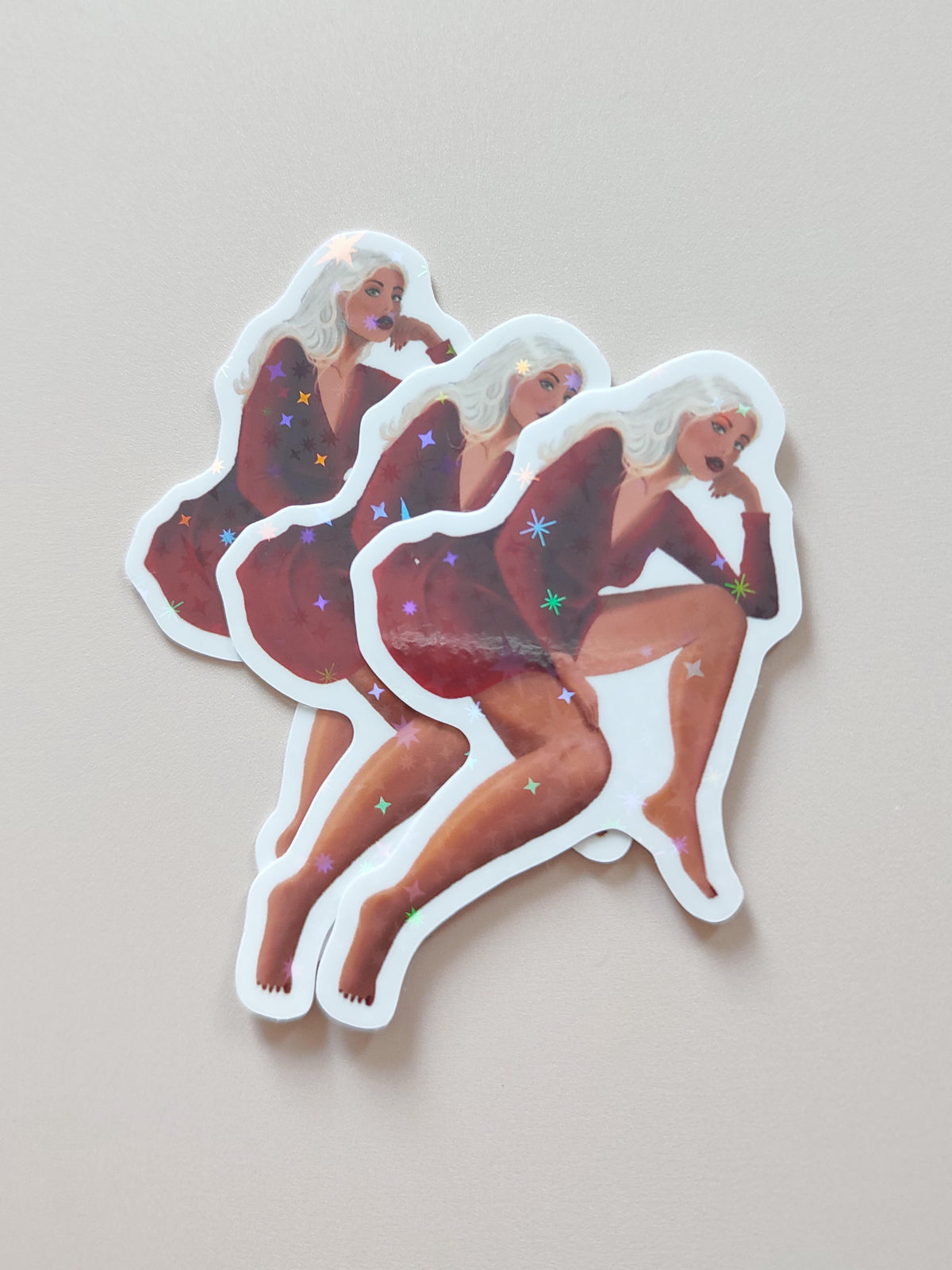 3 stickers Luna posés sur fond neutre montrant l'effet irisé du sticker au soleil