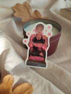 sticker holographique Stella sorcière posée devant une bougie et brillant au soleil
