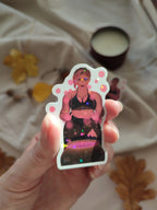 sticker holographique Stella, sorcière faisant de la magie rose devant un chaudron, gros plan et brillant au soleil